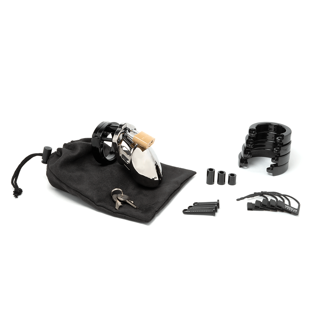 Fully-assembled chrome finish and black CB-6000s chastity cage on a black cotton storage pouch with 2 metal keys to left. 3 black spacers, 3 black locking pins, 4 black stacked U-rings and 5 black plastic locks lay displayed on right.